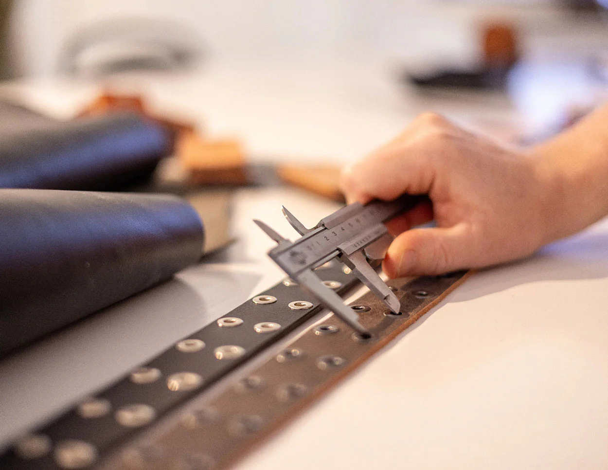 precision hole punching on a leather belt strap
