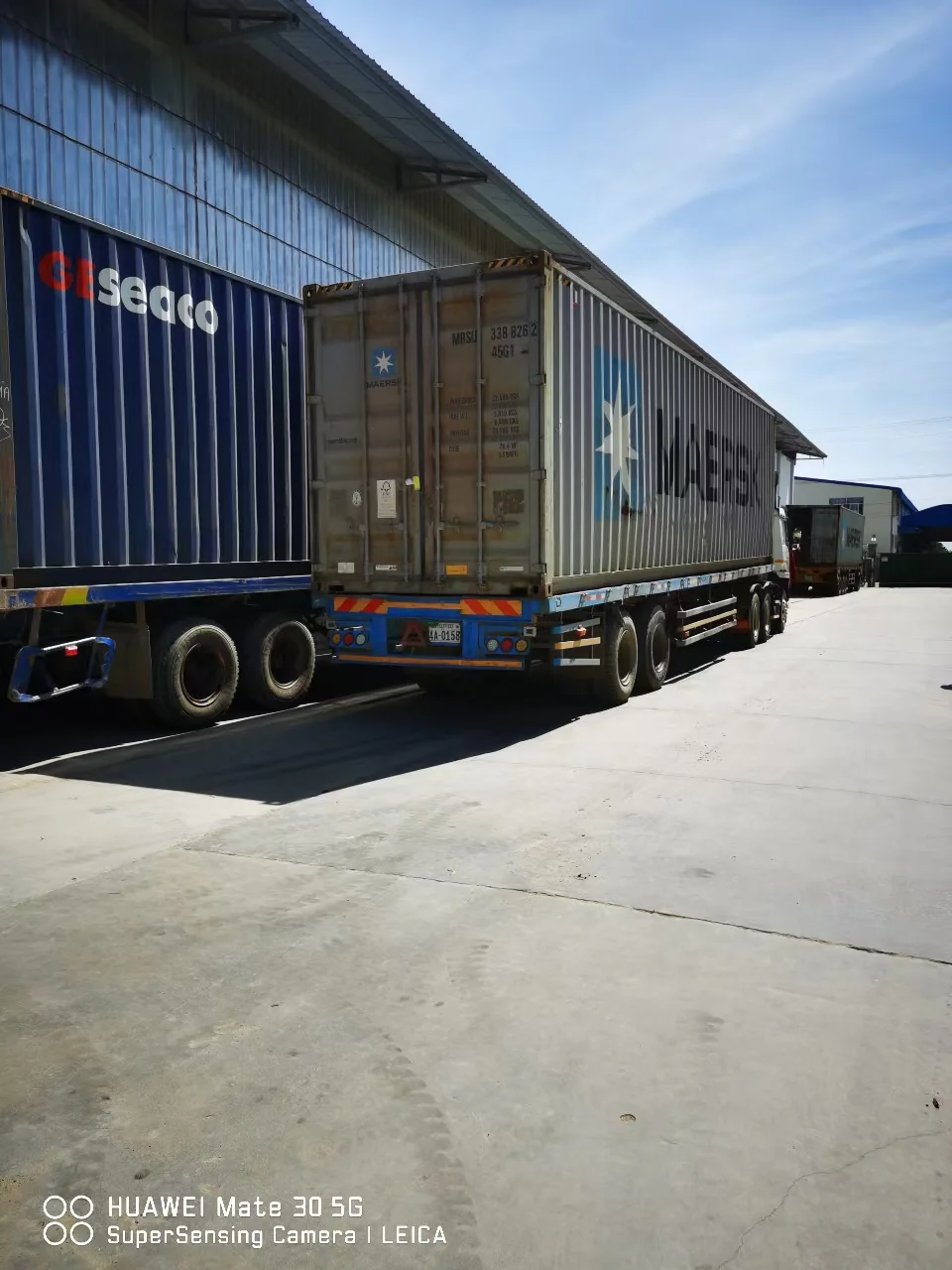 Export containers queued beside trucks at the HDbelt factory before dispatch