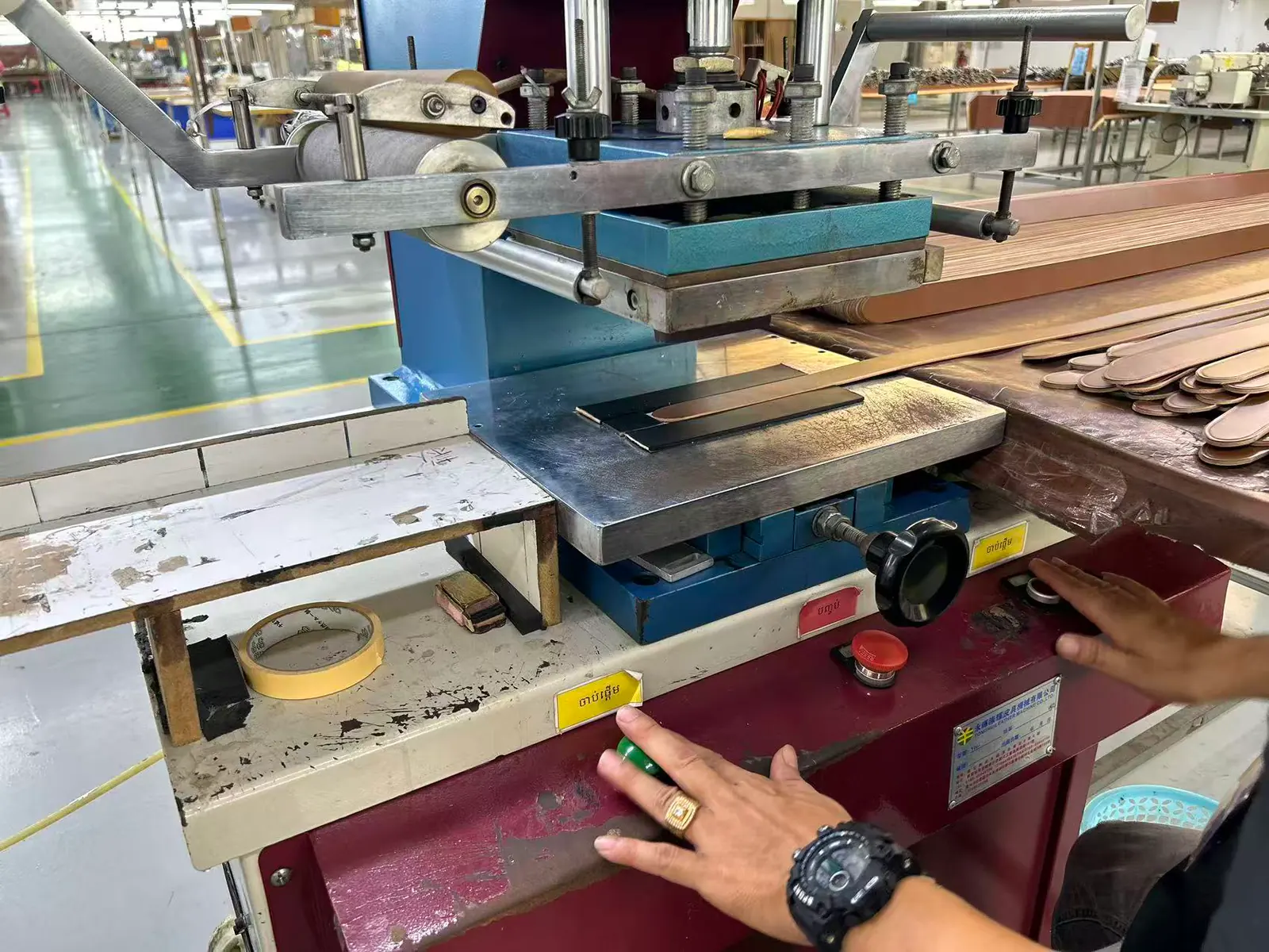 worker operating a belt strap cutting press