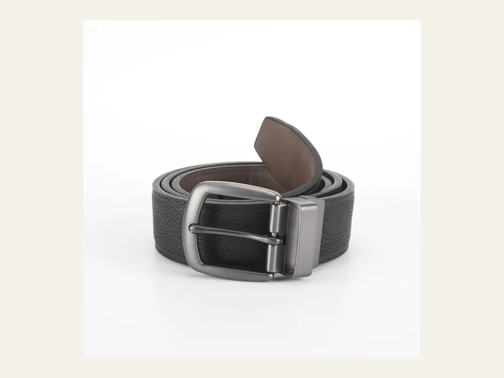 Dark reversible-style work belt with metal buckle on a neutral background