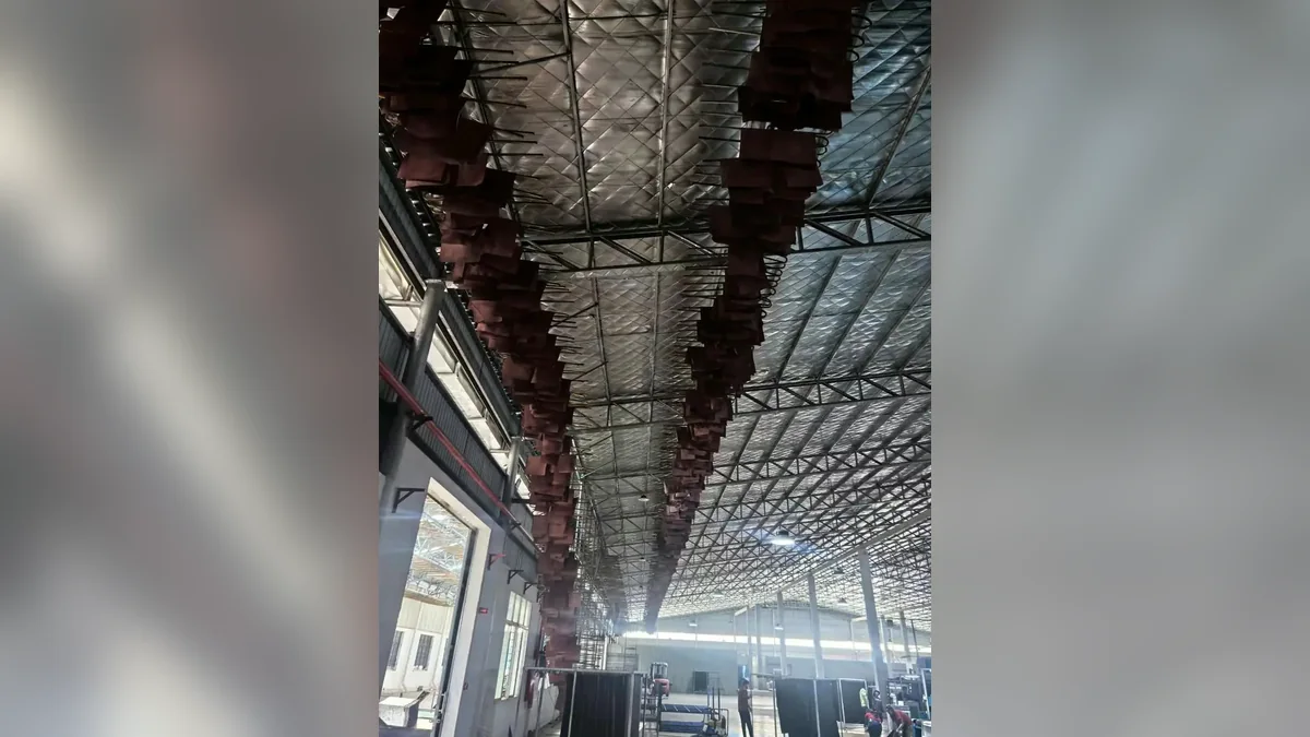 Leather hides hanging along an overhead factory drying line