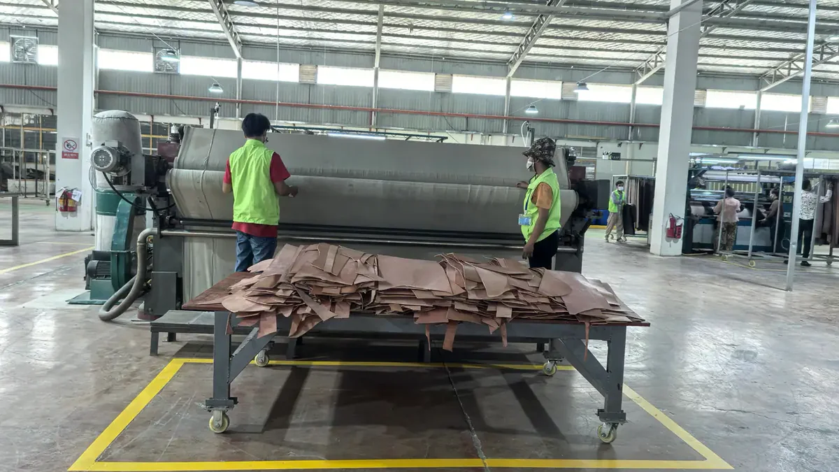 Workers operating a leather hide softening machine