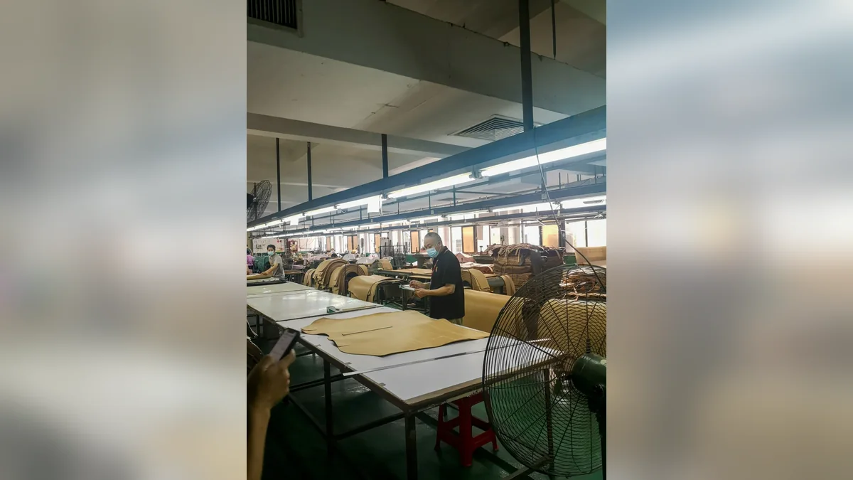 Leather cutting workshop with operators working at long tables
